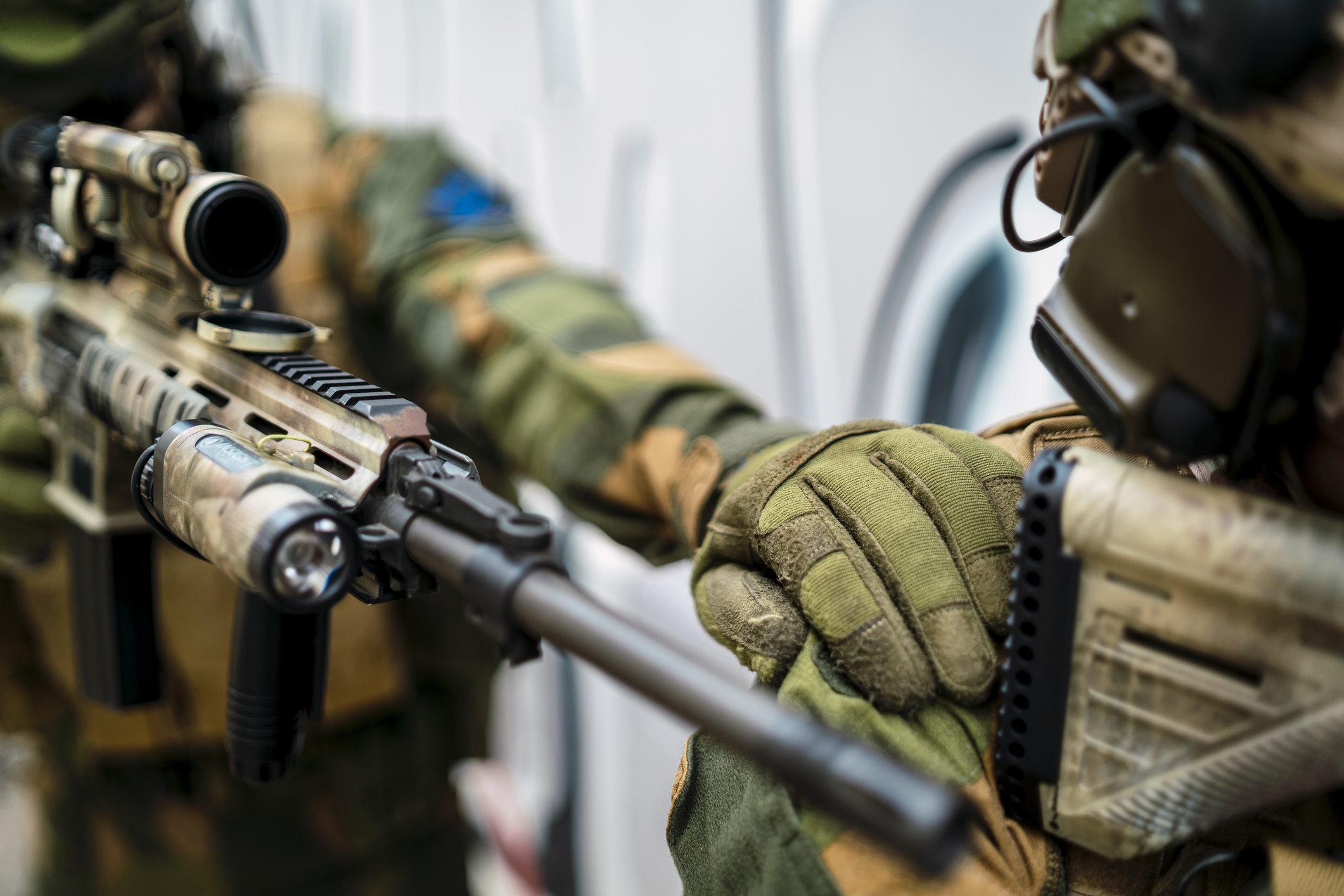 A special force soldier signalling his partner by tapping on his shoulder during an investigation